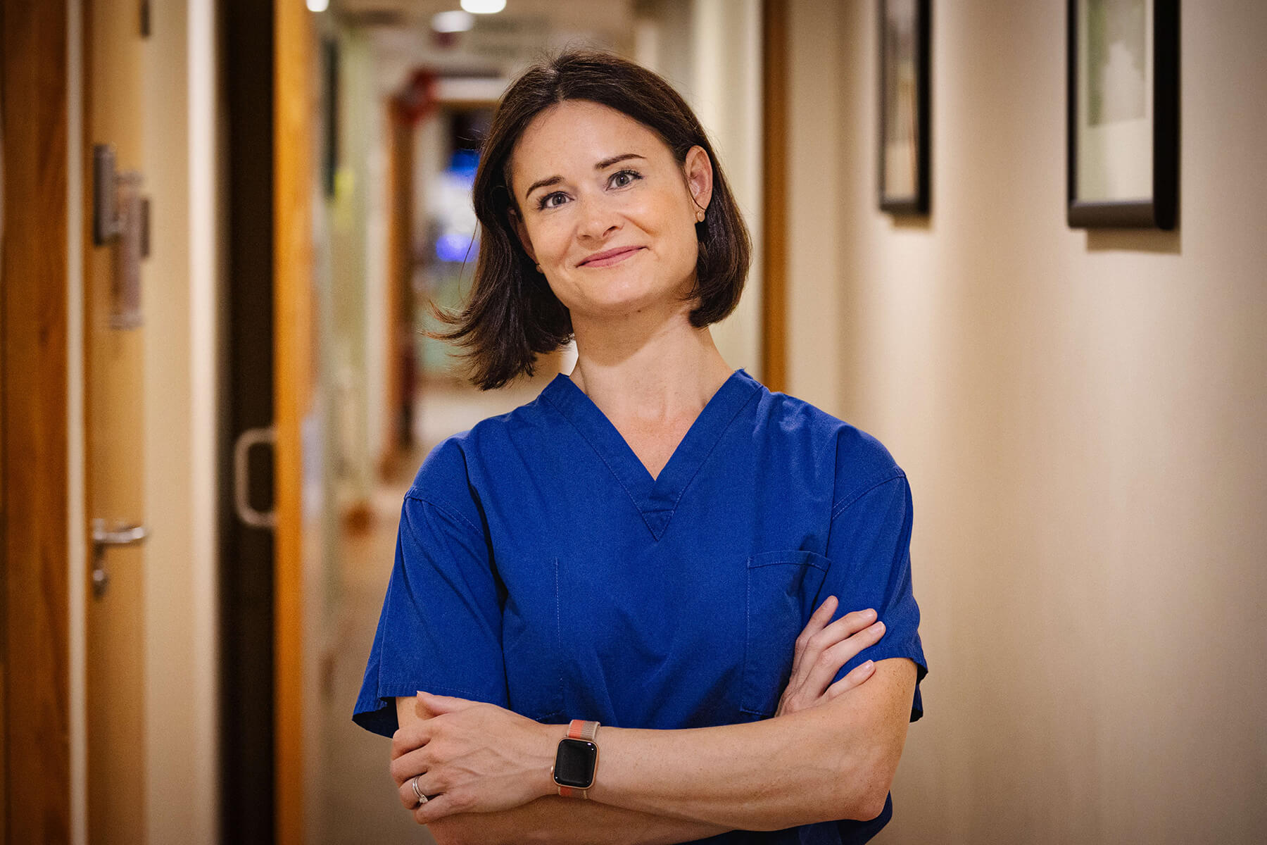 Naomi Goldstraw Exeter based Consultant Dermatologist in Scrubs Hospital corridor